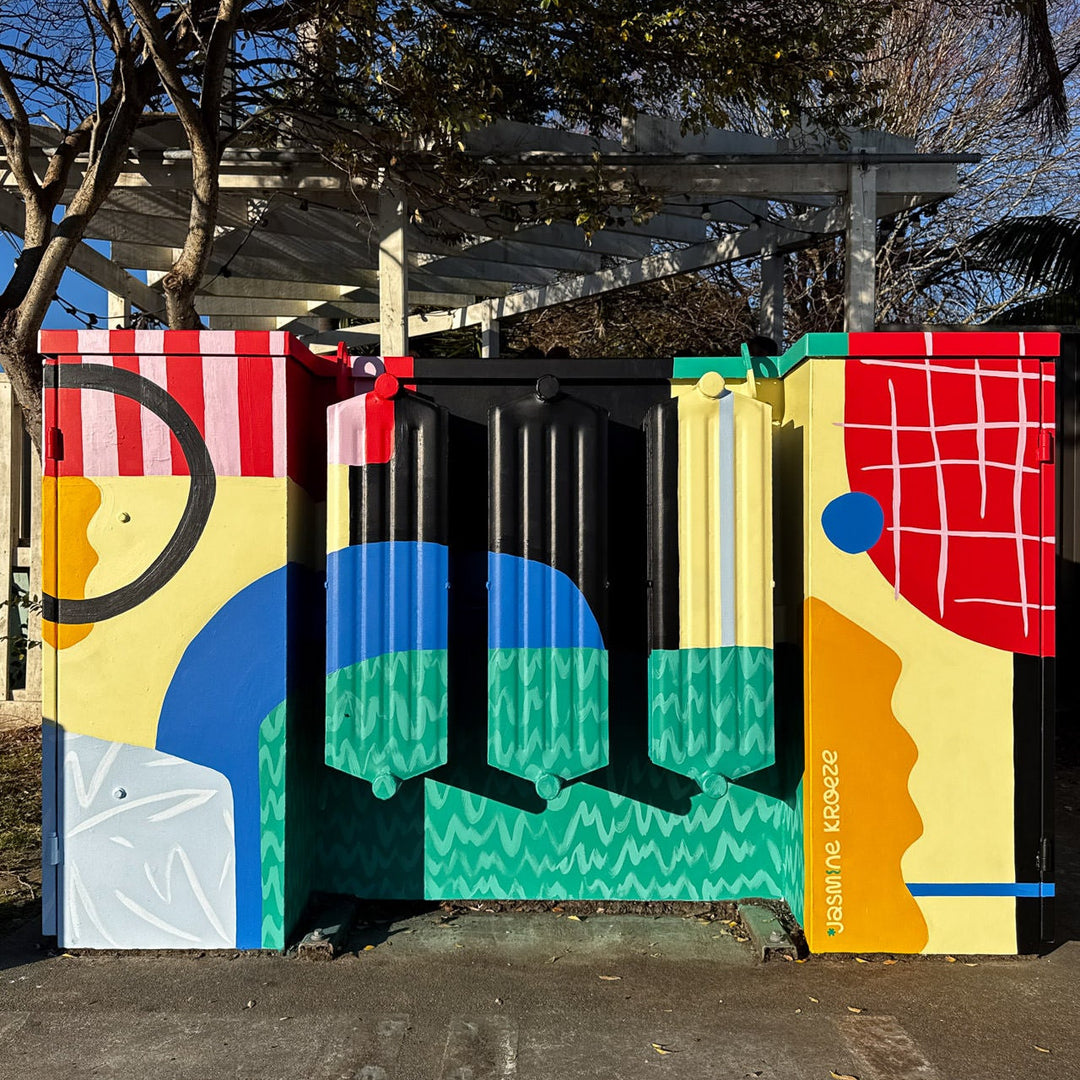 Colorful abstract mural on a transformer box with geometric shapes and patterns.