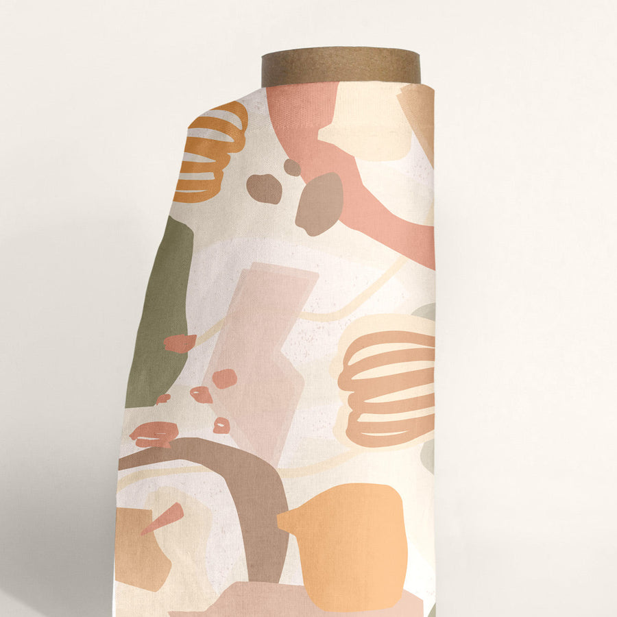 a roll of fabric with abstract textile design in pastel colours